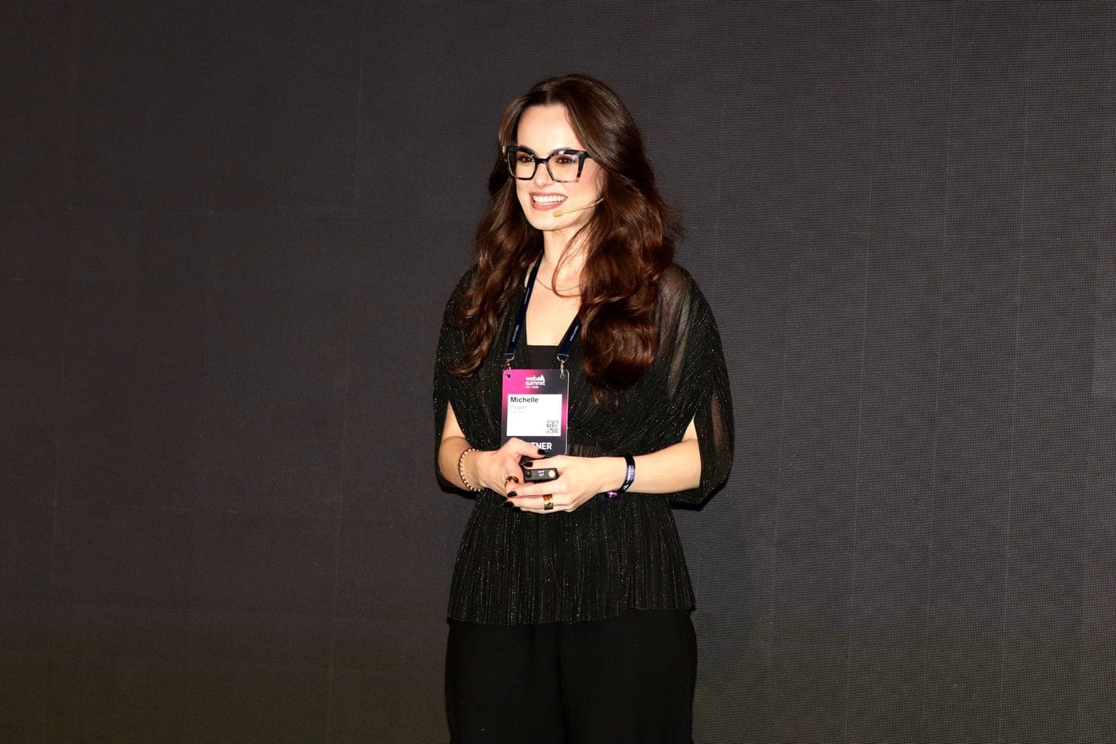 Palestrante Michelle Douglas no palco do Web Summit Rio 2026, falando de moda e inteligência artificial · fashion tech, fashion AI e OUR SPACE