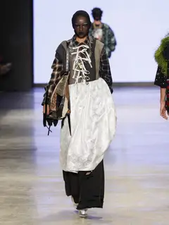 Look 27: colete, camisa, saia, calça